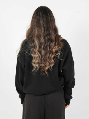 Woman wearing a black oversized sweatshirt on a white background
