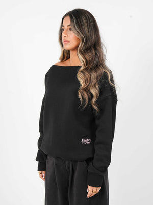 Woman wearing a black sweatshirt with a logo on a white background