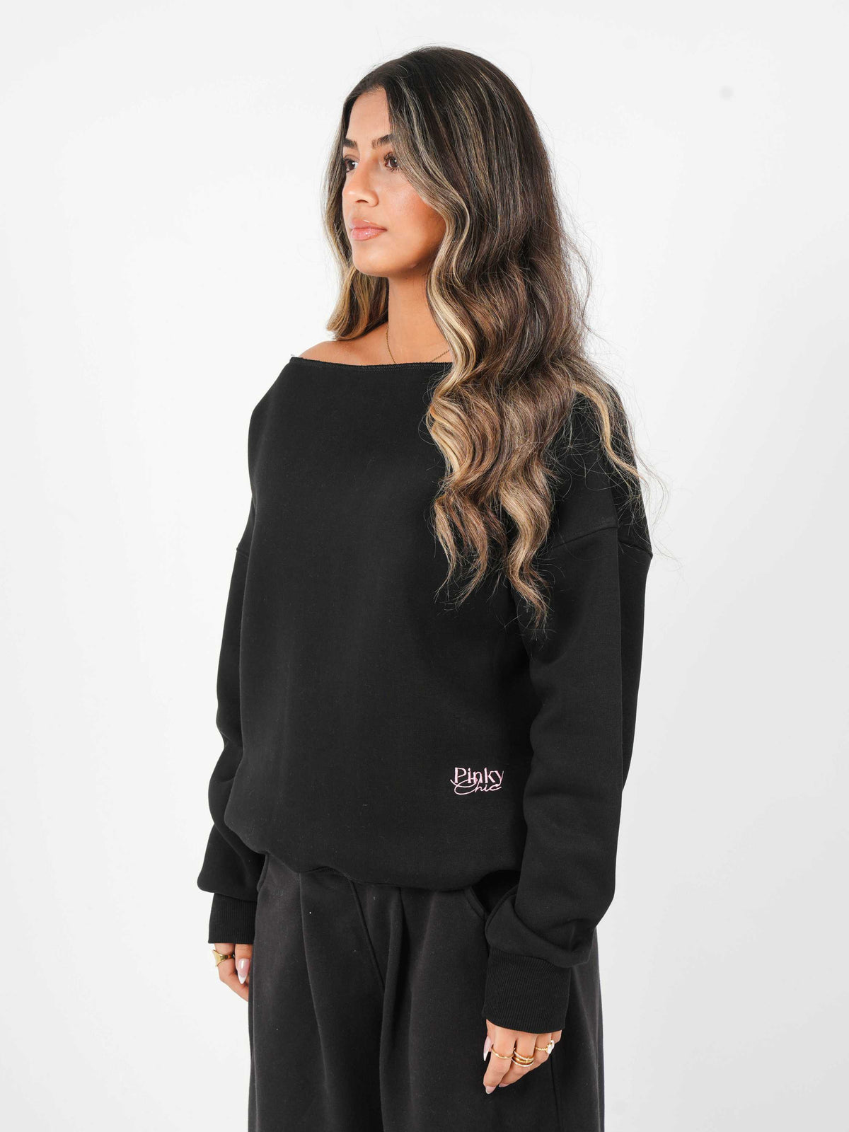 Woman wearing a black sweatshirt with a logo on a white background