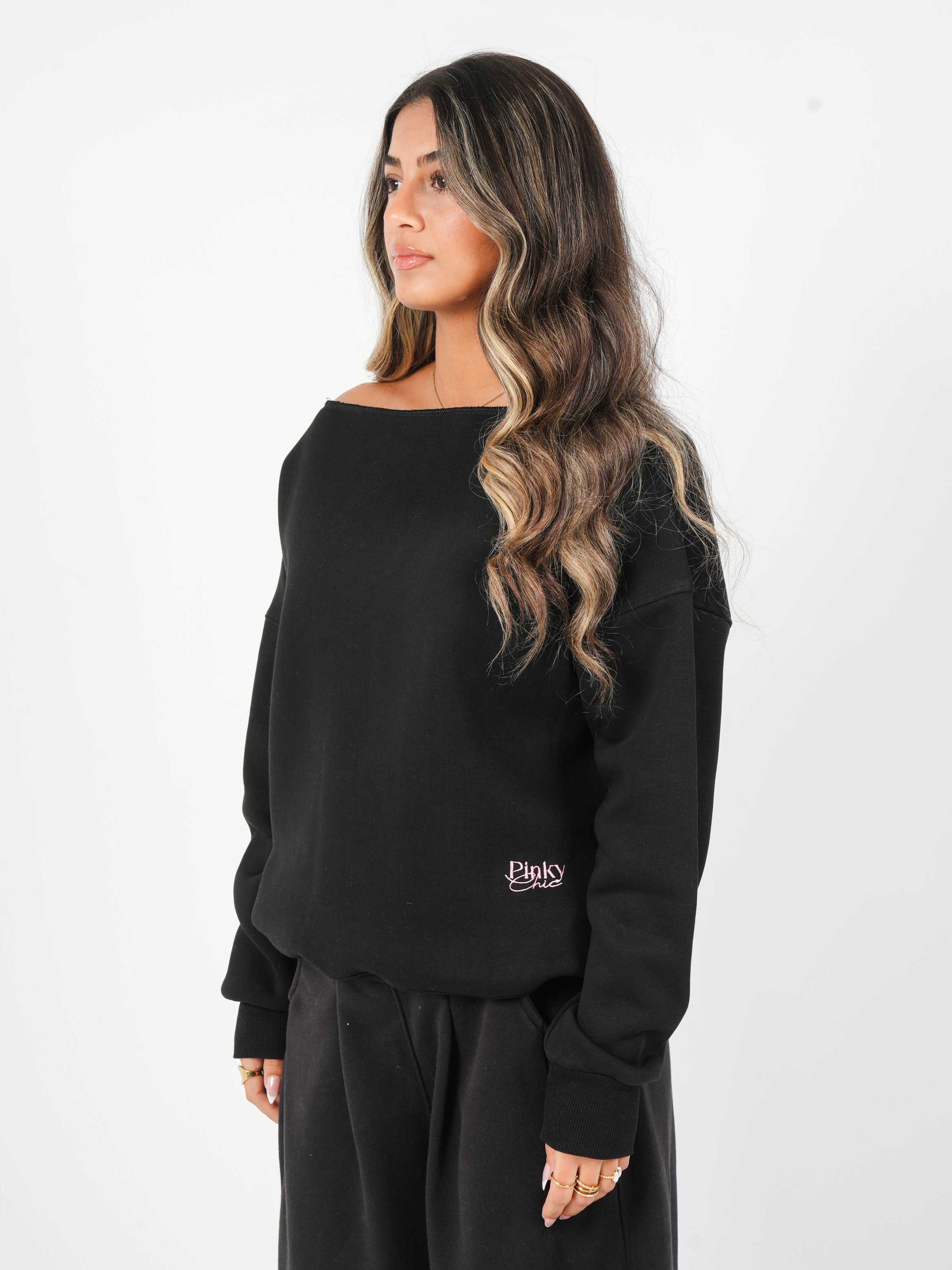 Woman wearing a black sweatshirt with a logo on a white background