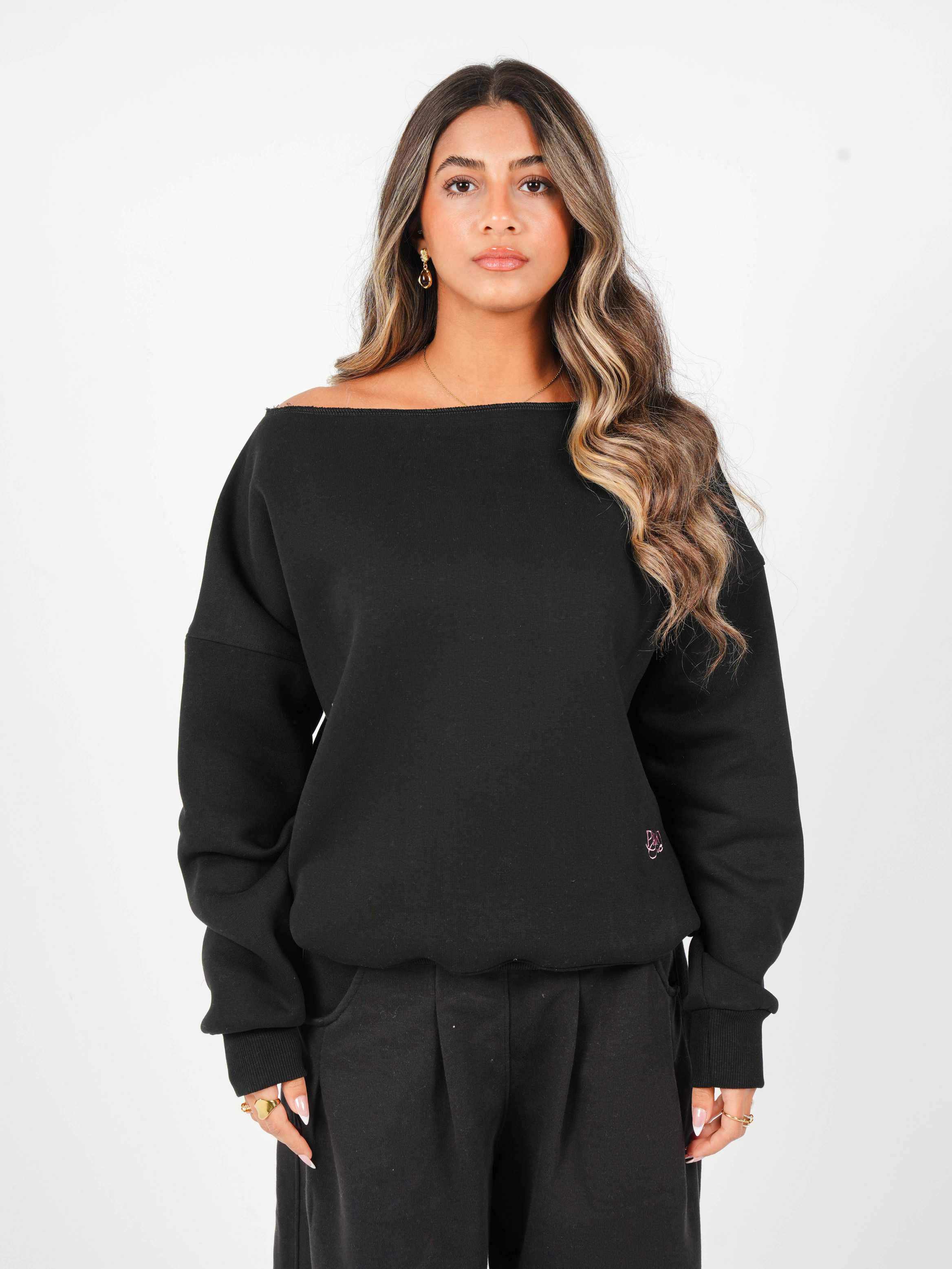 Woman wearing a black oversized sweatshirt on a white background