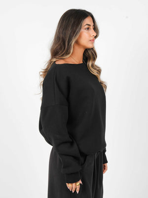 Woman wearing a black oversized sweatshirt on a white background